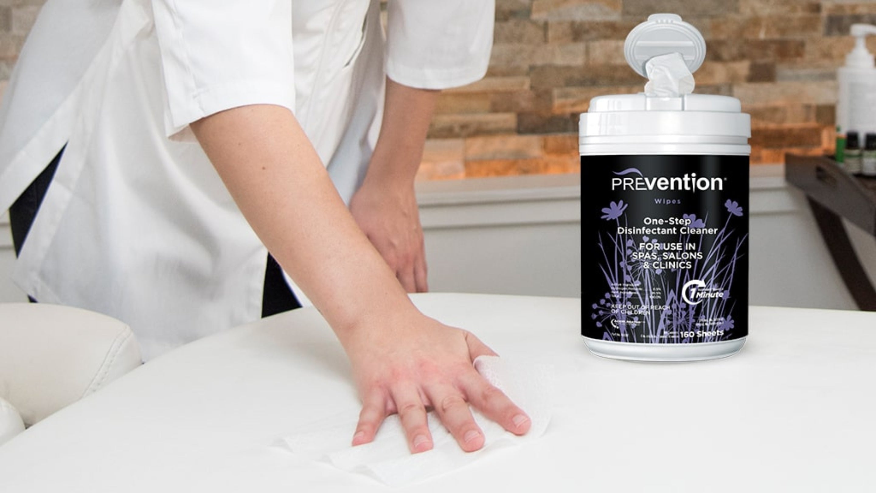 Person cleaning a spa table with Prevention disinfectant cleaning wipes.